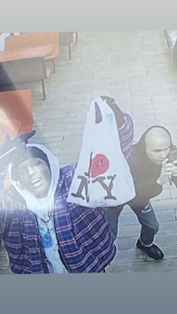 a man in a hoodie is holding a bag