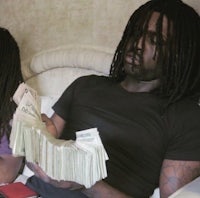 two people sitting on a bed with money in their hands