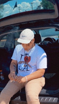 a man sitting in the trunk of a car smoking a cigarette