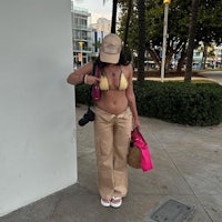 a woman in a tan bikini standing on the sidewalk