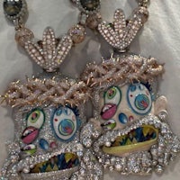 two diamond necklaces with faces on them