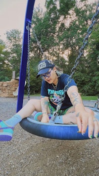 a woman sitting on a swing in a park