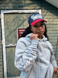 a woman wearing a hoodie and a hat