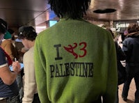 a man wearing a green sweater with the words i love palestine